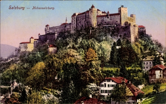 Salzburg in Austria, Hohensalzburg Castle, green hills, houses in the foreground
