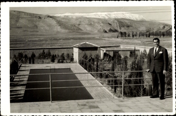 Postcard Persepolis Shiraz Iran, man in suit, villa, pool, mountain landscape, sunny atmosphere